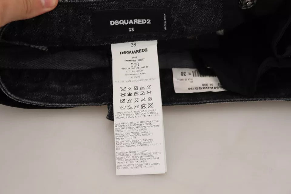 Jupe en jean noire déchirée, coupe mi-hauteur et style A-line, de la marque Dsquared², portée avec détails usés.