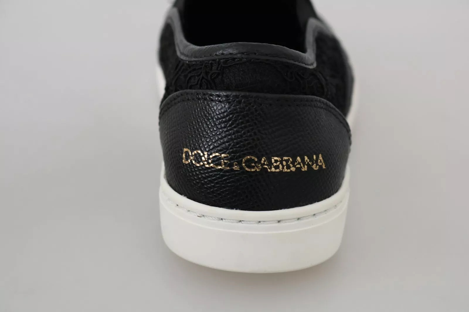 Chaussures plates noires Dolce & Gabbana en cuir avec logo en dentelle et slip-on, style élégant et confortable.