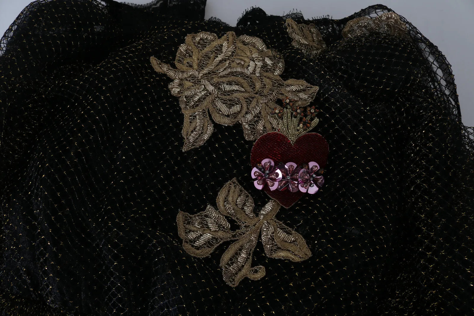 Robe en forme A Dolce & Gabbana noire avec cristaux dorés et cœur, élégante et sophistiquée, vue de face sur un fond neutre.