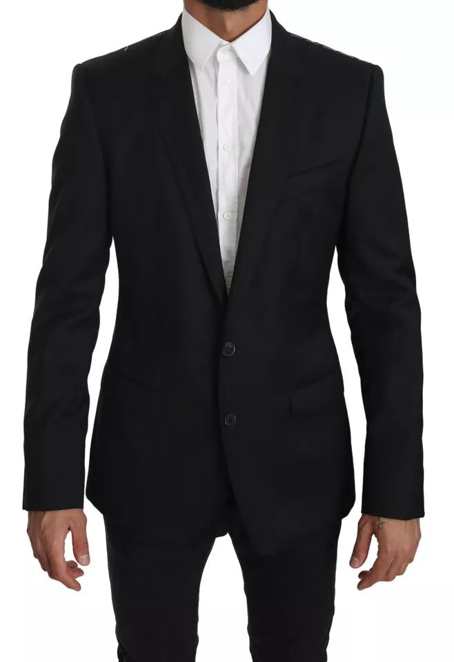 Veste blazer noire Dolce & Gabbana slim, élégante, en tissu structuré, portée sur un fond neutre.
