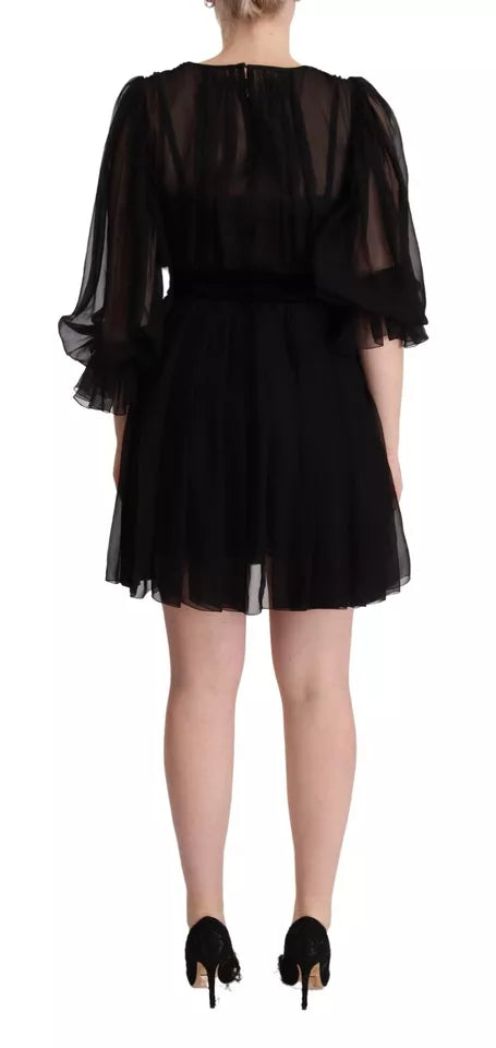 Robe noire Dolce & Gabbana à col en V, manches longues, coupe mini A-line, en tissu élégant.