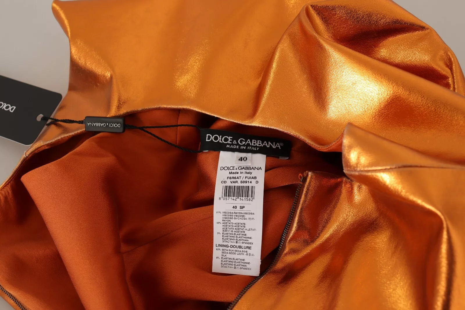 Robe sans manches dorée et orange en satin de Dolce & Gabbana, coupe moulante et élégante.