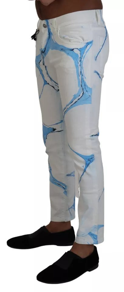 Jeans skinny en denim blanc et bleu de Dolce & Gabbana, coton, ajustés, avec détails modernes, visibles sur l'image.