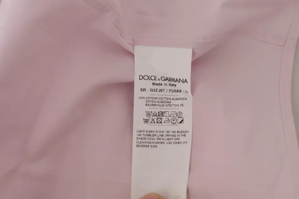 Chemise dorée Dolce & Gabbana et robe en coton rose clair pour homme, tenue formelle élégante, visible en image.