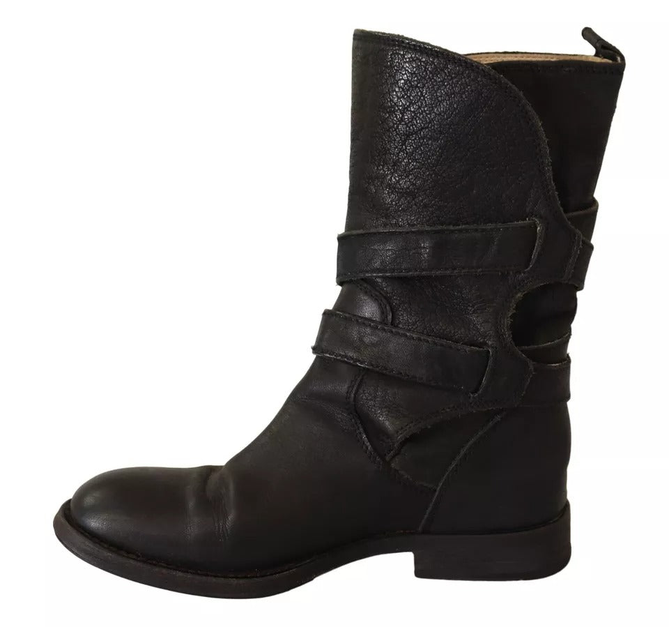 Chaussures Bottines en cuir noir Dolce & Gabbana avec boucle, mi-mollet, élégantes et modernes, visibles en gros plan.