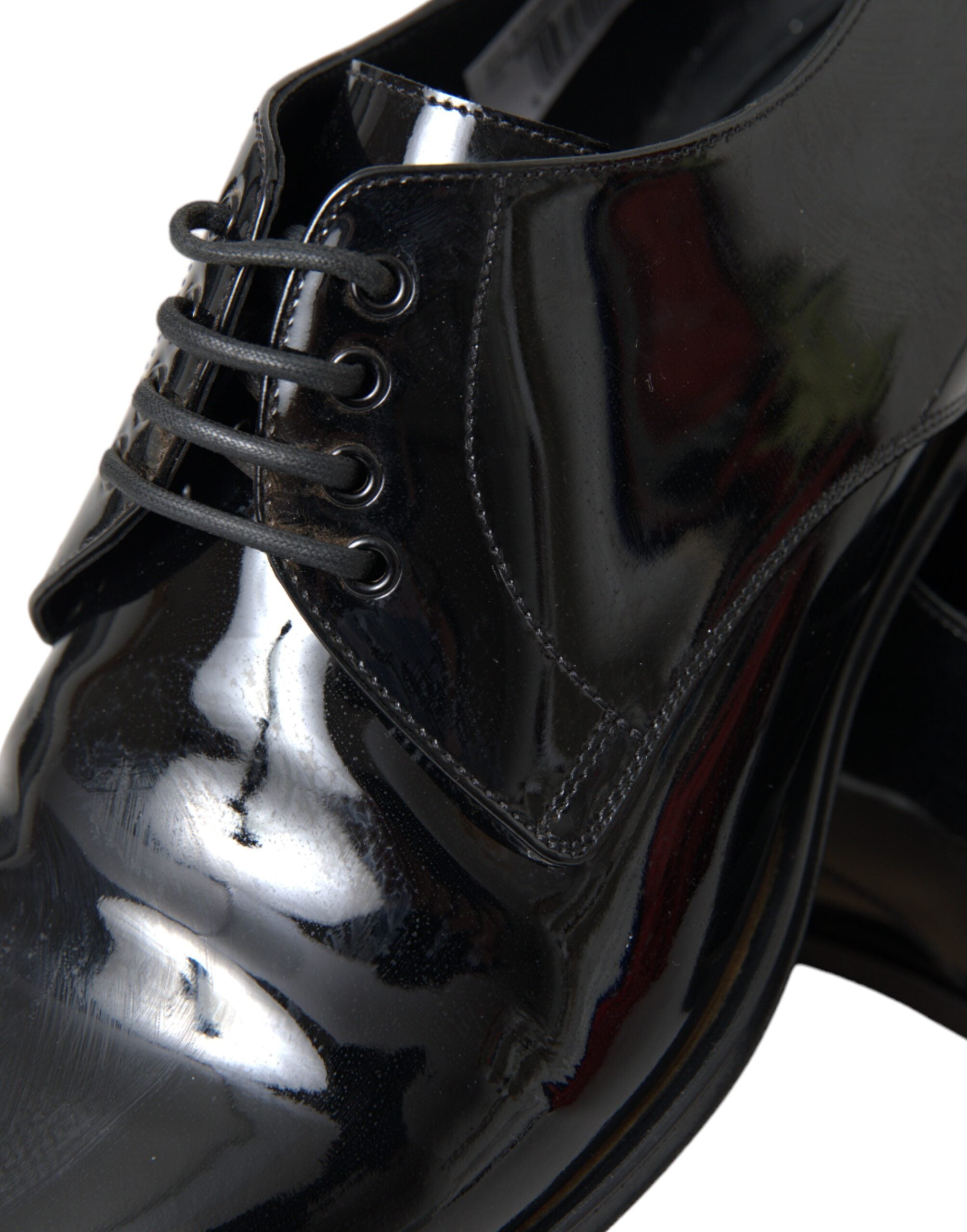 Chaussures derby noires en cuir verni Dolce & Gabbana pour une tenue formelle élégante, vues de face sur fond blanc.