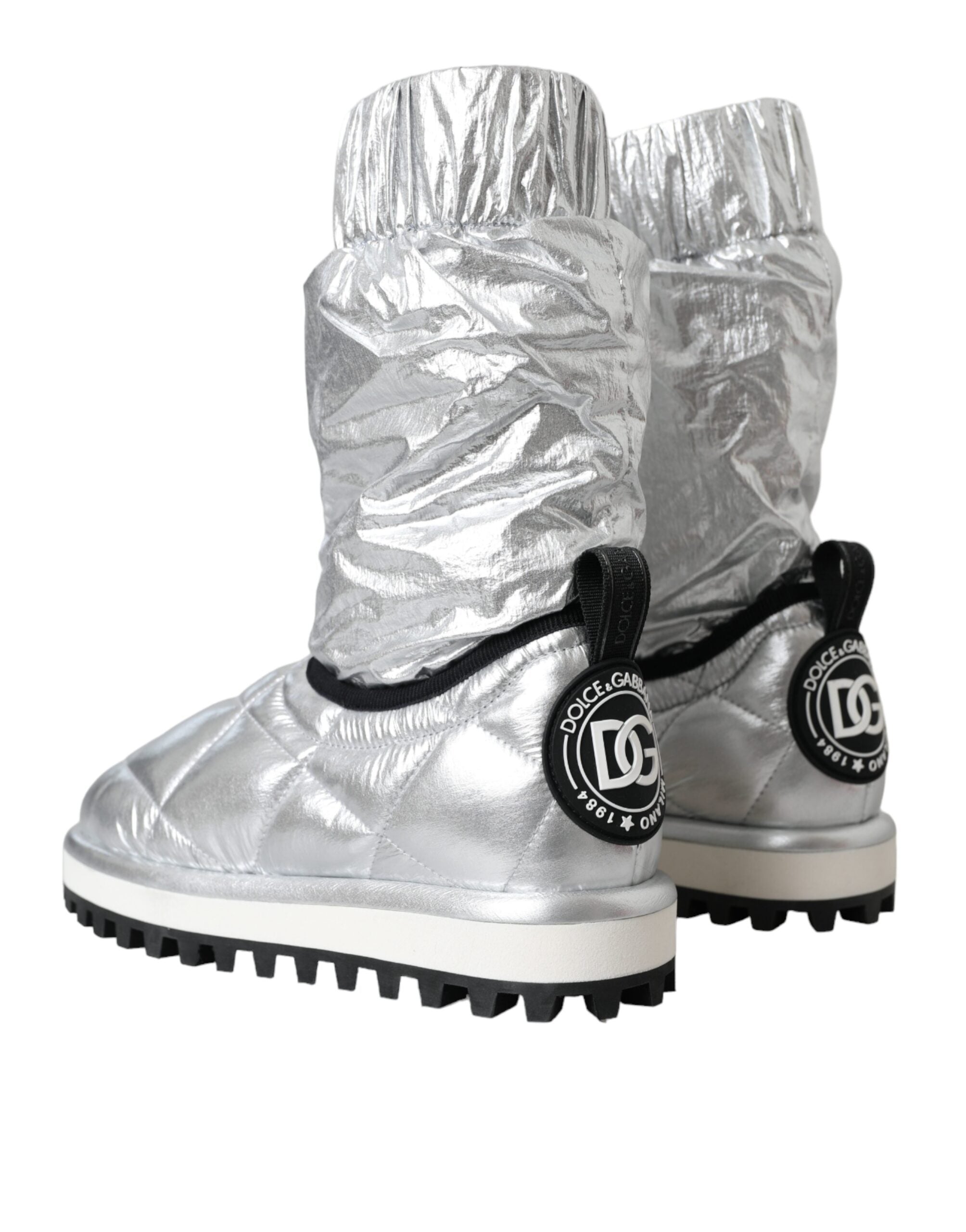 Bottes en métal argenté Dolce & Gabbana avec matelassage, logo brodé et semelle robuste, mode élégante et moderne.