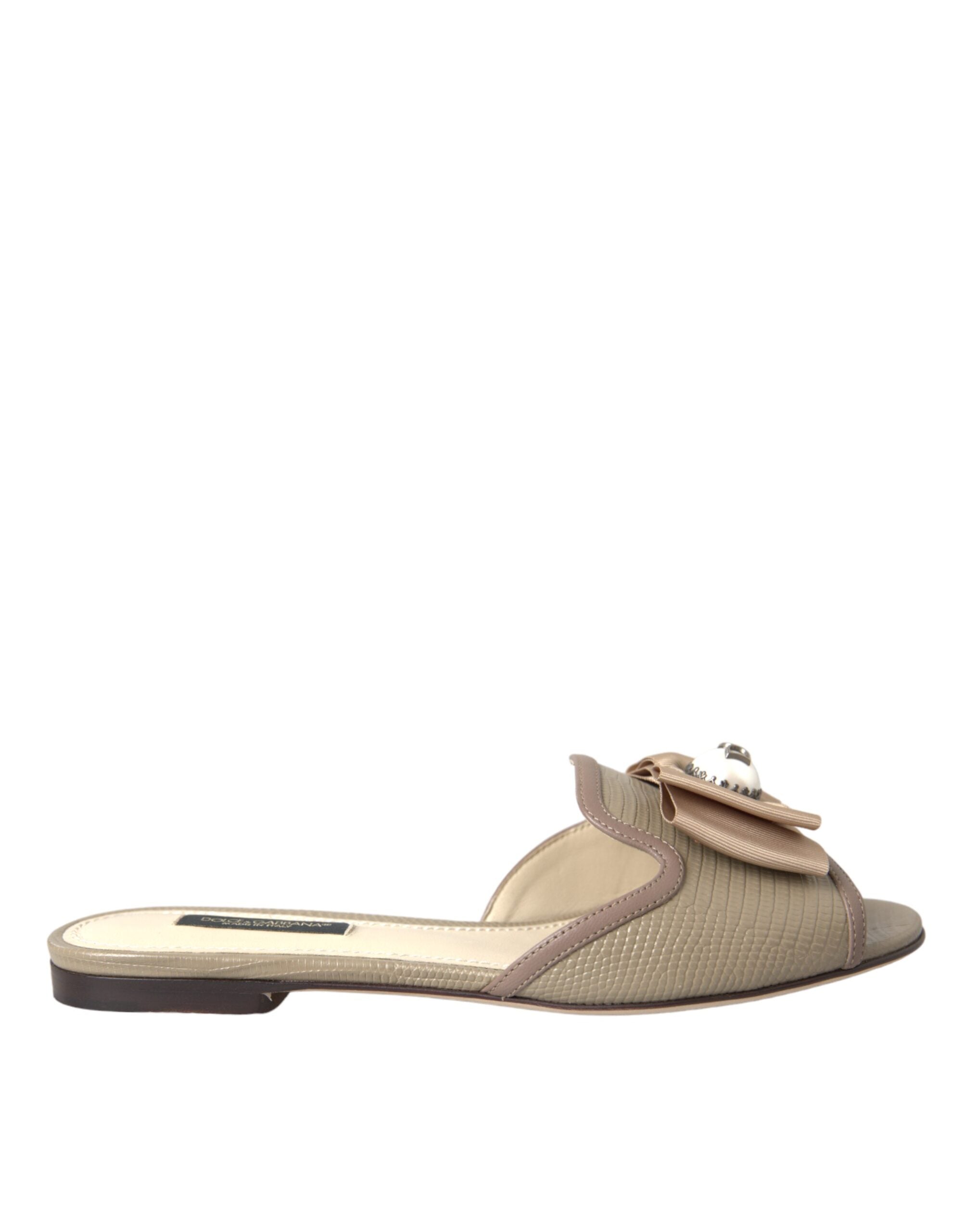 Sandales plates Dolce & Gabbana beige avec logo, perles et design élégant, parfaites pour un style sophistiqué.