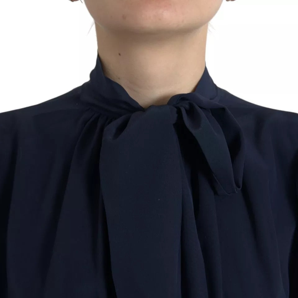 Blouse Dolce & Gabbana à manches longues bleue avec col ascot, style élégant et sophistiqué.