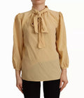 Chemisier en soie Dolce & Gabbana avec col ascot moutarde, style élégant et sophistiqué, détail de la blouse.