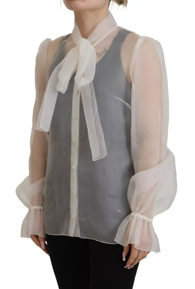 Chemisier blanc Dolce & Gabbana à col ascot et manches longues, élégant et sophistiqué, détail du tissu et de la coupe visible.