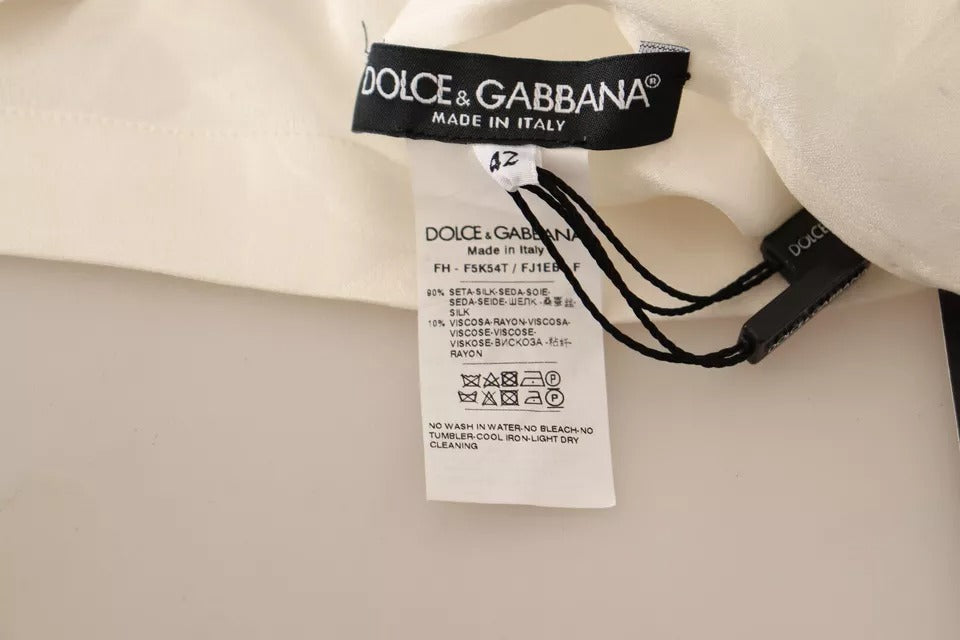 Chemise blanche Dolce & Gabbana en soie avec col ascot et boutons, style élégant et sophistiqué.