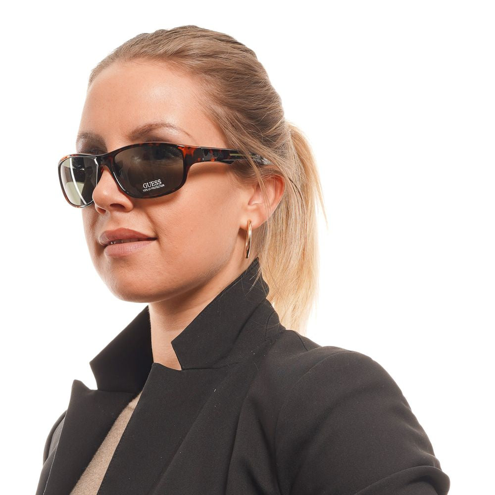 Lunettes de soleil en plastique marron Guess avec monture élégante et branches épaisses, style moderne et tendance.