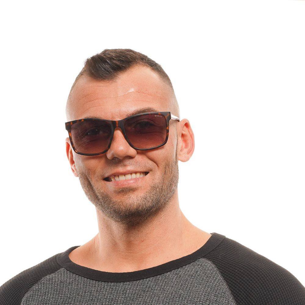 Lunettes de soleil en plastique marron Guess avec monture élégante et design moderne, vues de face.