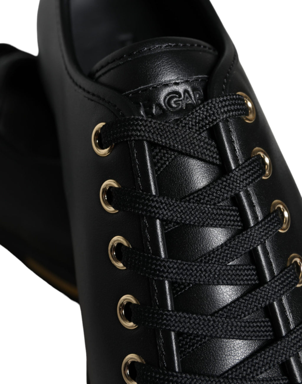 Chaussures sneakers classiques en cuir noir et or de Dolce & Gabbana, style élégant et sophistiqué, vue en gros plan.