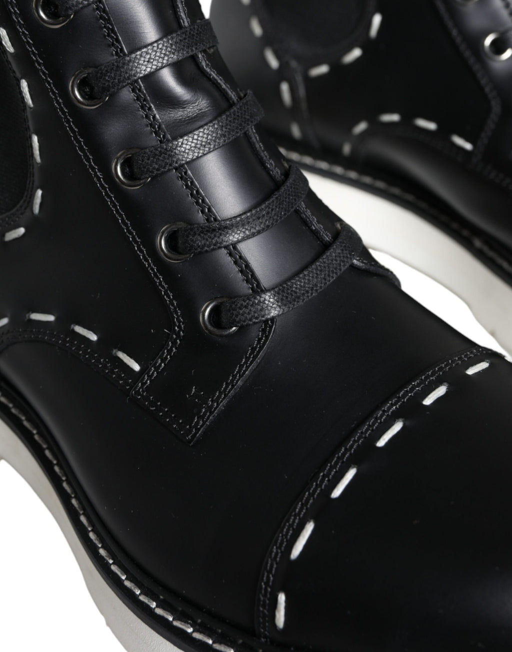 Bottes combat en cuir noir Dolce & Gabbana, mi-mollet, avec boucle, style robuste et élégant, chaussures de mode sophistiquées.