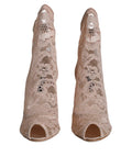 Bottes Dolce & Gabbana Taormina en dentelle beige, extensibles, avec semelle en cuir et détails élégants pour un style sophistiqué.