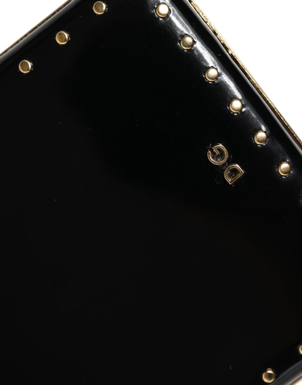 Sac clutch en cuir noir Dolce & Gabbana avec studs, cadre doré, idéal pour soirée.