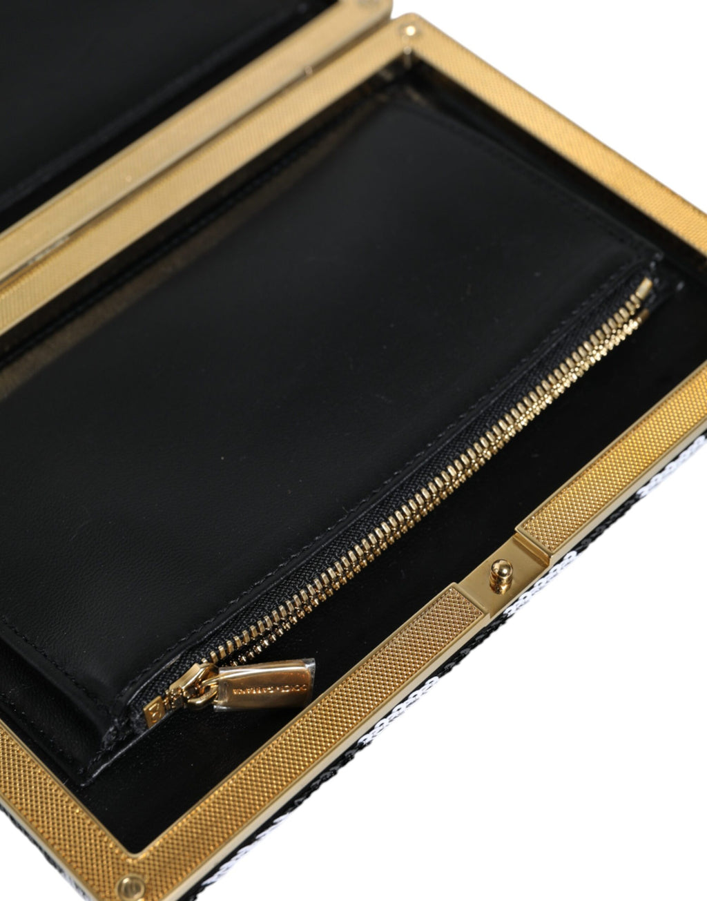 Pochette de soirée Dolce & Gabbana noire, blanche et or avec cadre élégant, idéale pour fêtes et événements élégants.