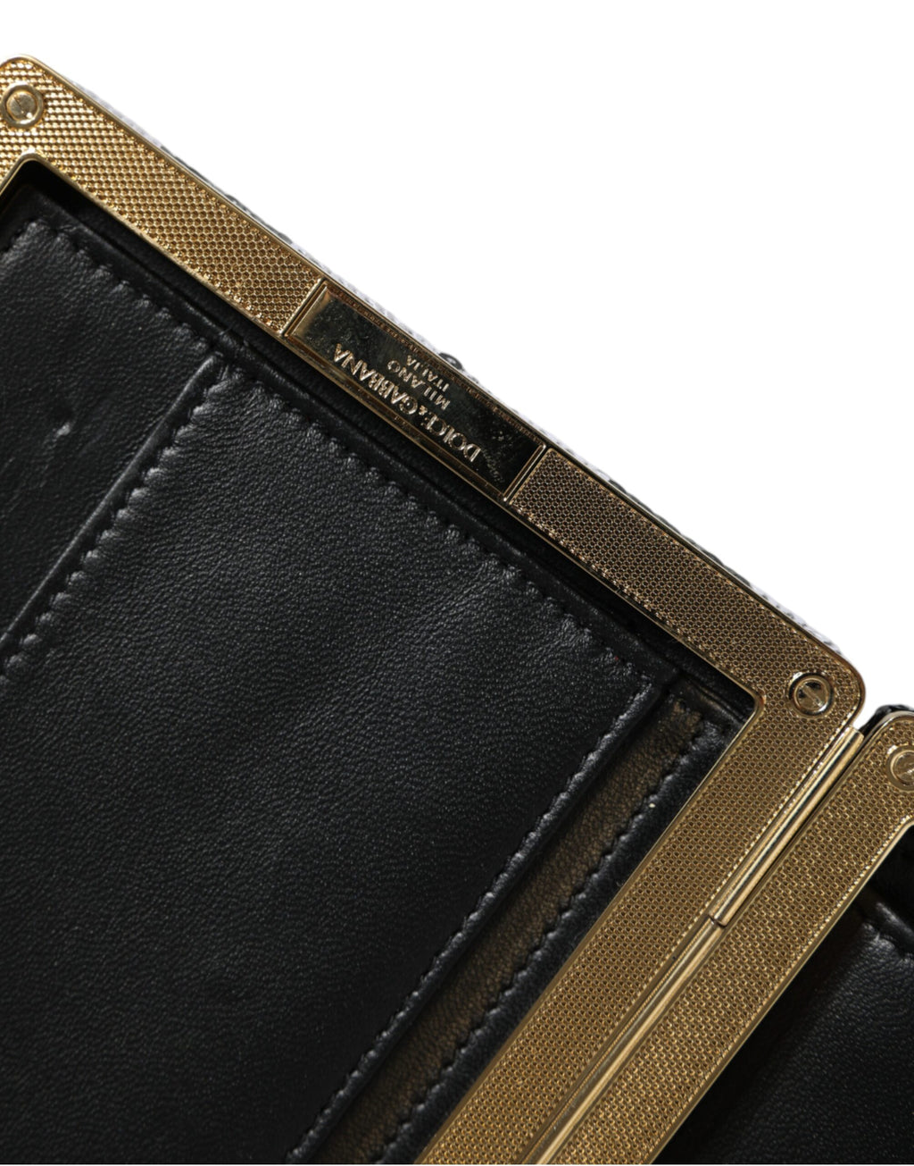 Sac pochette Dolce & Gabbana noir et blanc avec cadre doré, parfait pour soirée et événements élégants.
