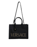 Sac à main tote à logo Versace en toile noire et cuir avec poignée, idéal pour transporter des objets avec style.
