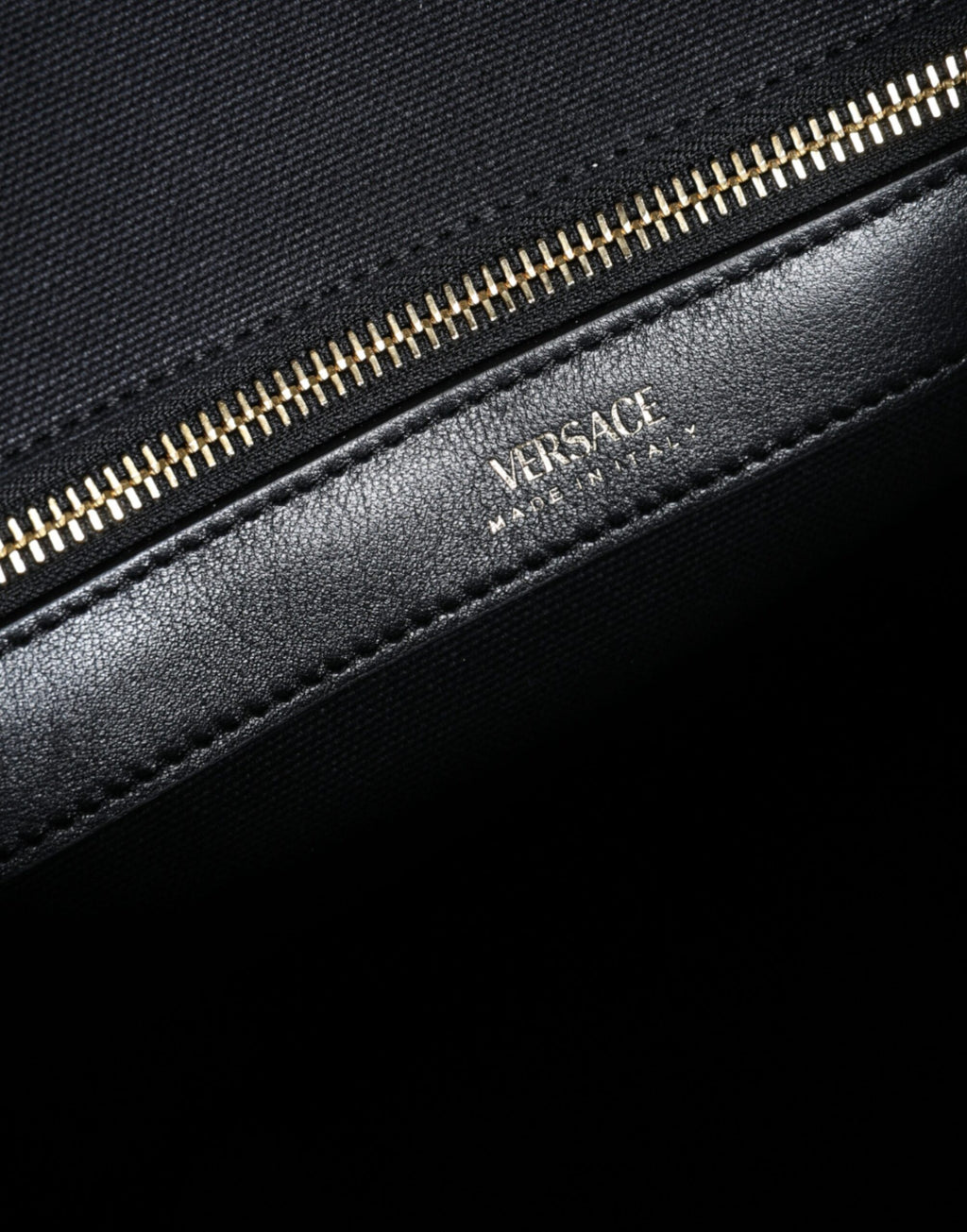 Sac cabas à main Versace noir en toile et cuir avec logo, porté en main, élégant et pratique pour le quotidien.