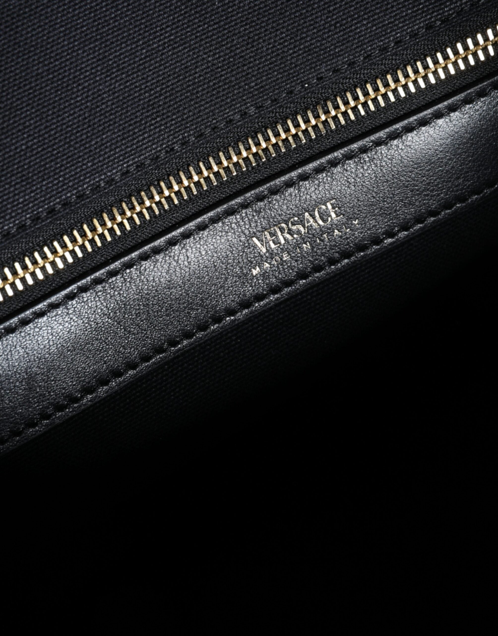 Sac cabas à main Versace noir en toile et cuir avec logo, porté en main, élégant et pratique pour le quotidien.