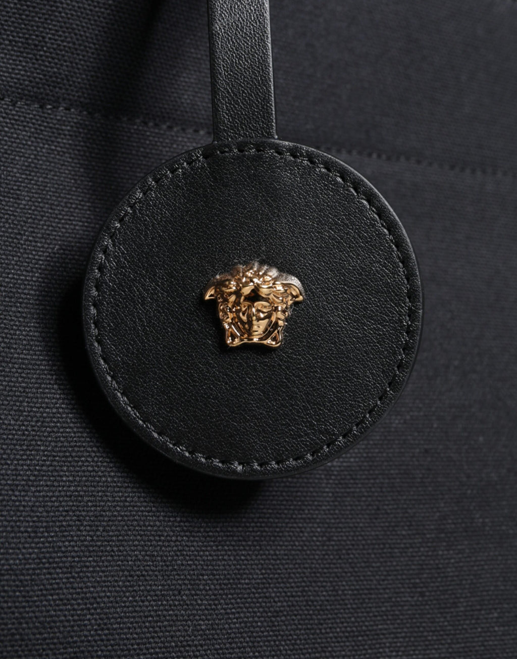 Sac à main tote à bandoulière noir Versace en toile et cuir avec logo, poignée en cuir, style élégant et pratique.
