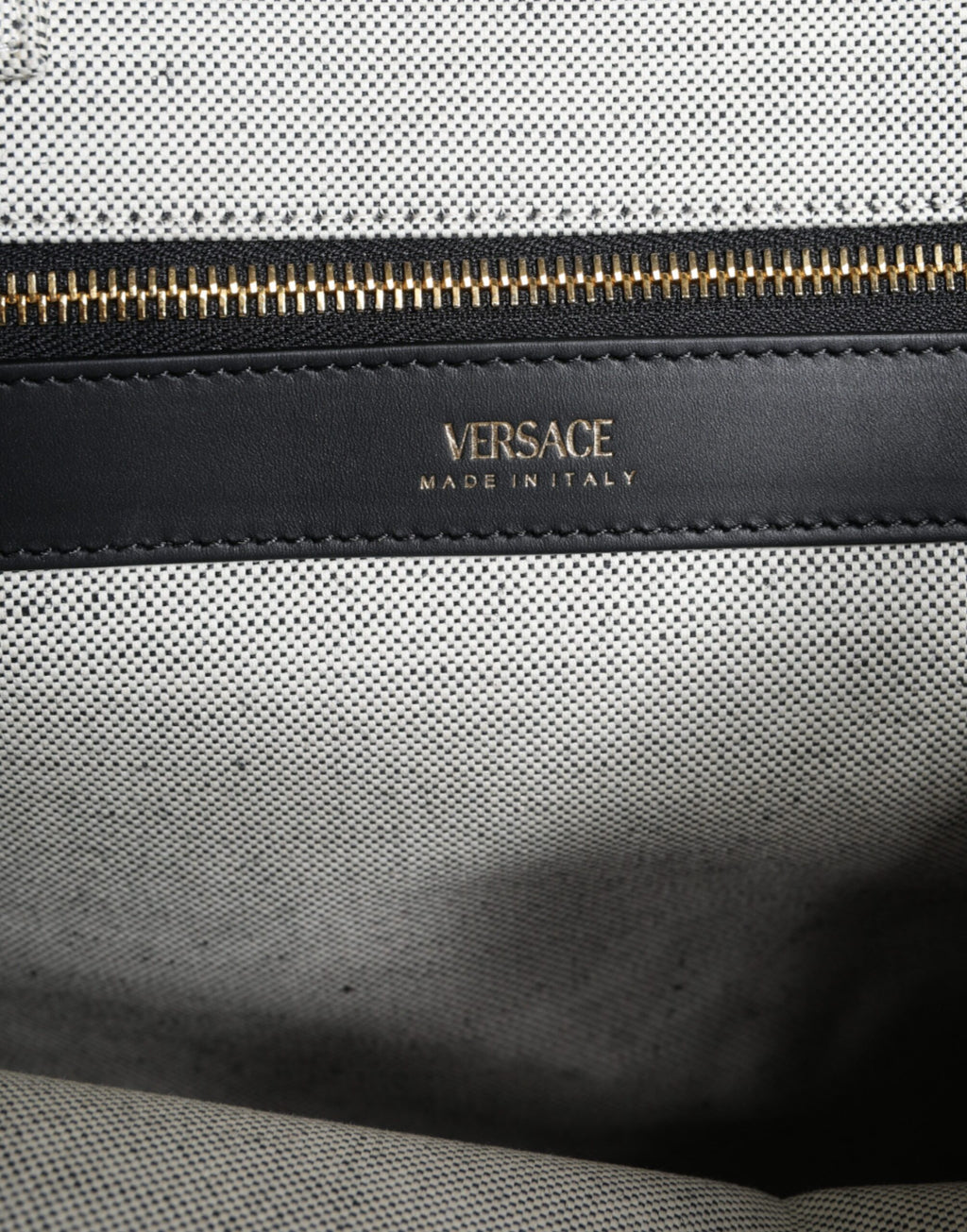 Sac à main bandoulière Versace en toile blanche avec logo en cuir, modèle tote à poignée centrale.