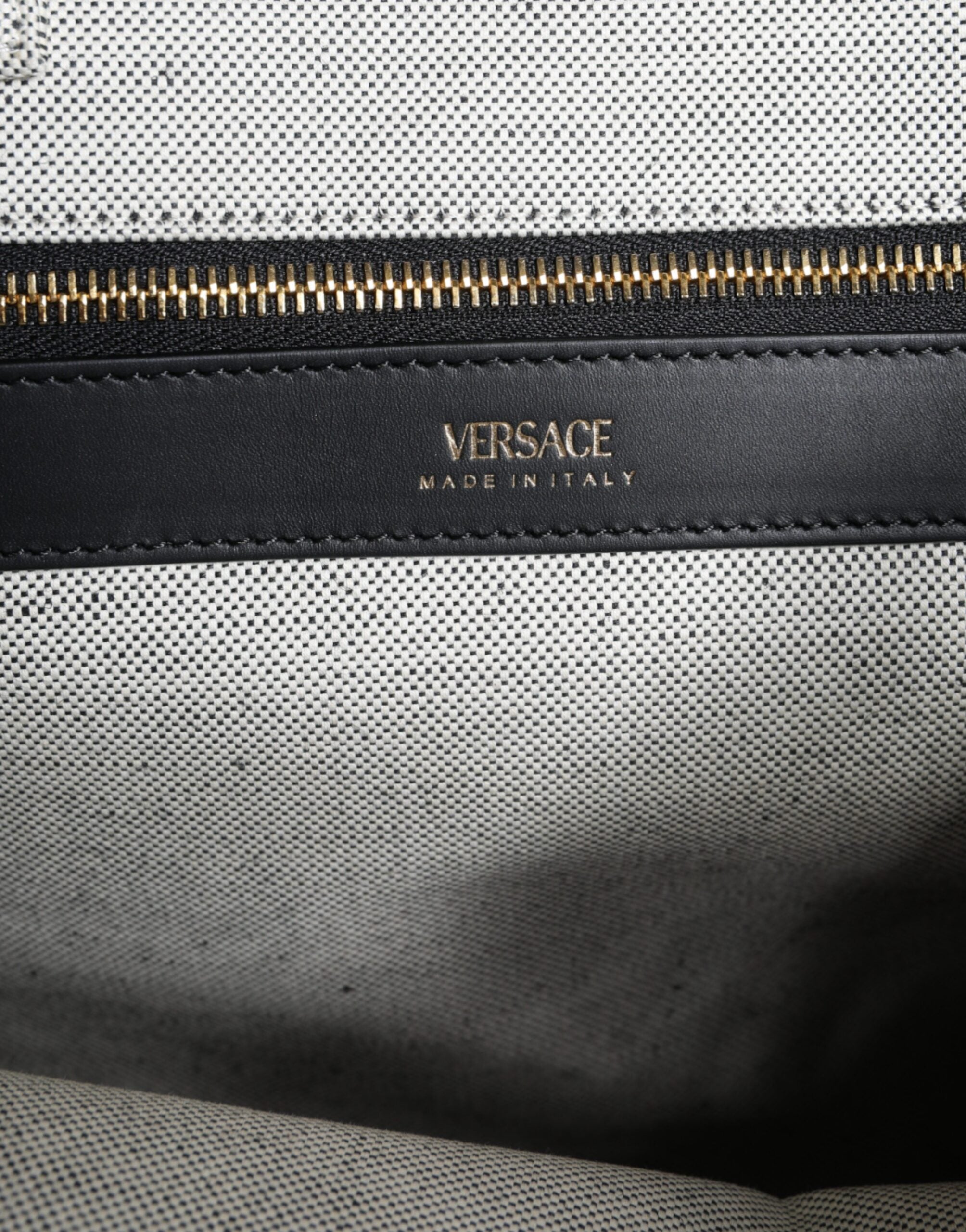 Sac à main bandoulière Versace en toile blanche avec logo en cuir, modèle tote à poignée centrale.