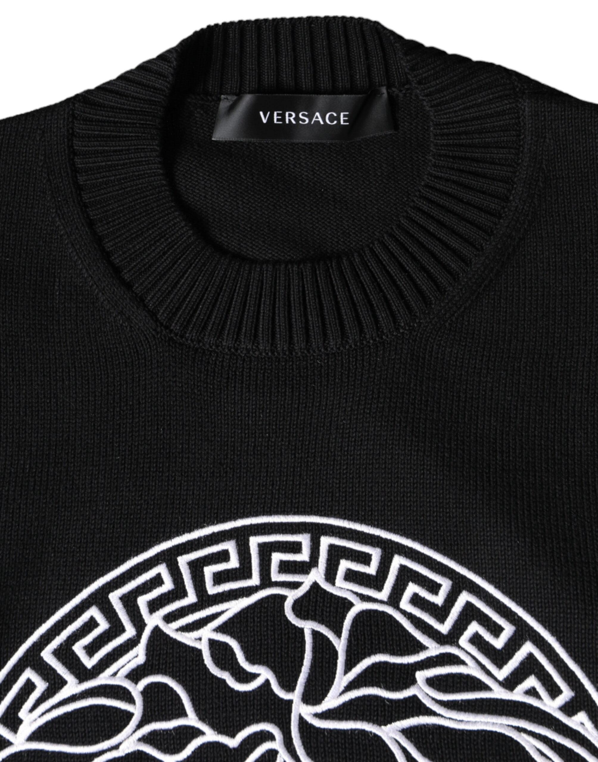 Pull-over noir Versace avec broderie Medusa, col rond et motif emblématique, en tissu doux et élégant.