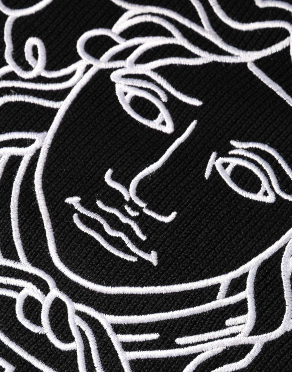Pull en maille noir Versace avec broderie Medusa sur le col ras du cou, style élégant et sophistiqué.