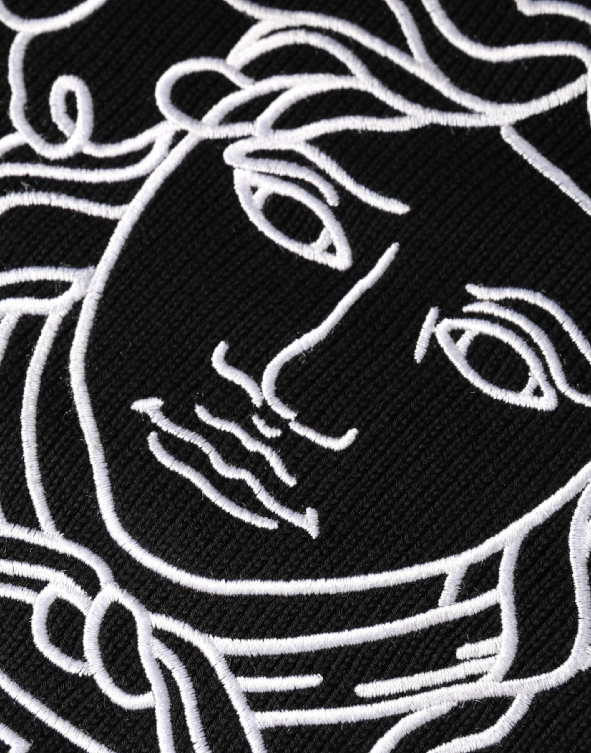 Pull en maille noir Versace avec broderie Medusa sur le col ras du cou, style élégant et sophistiqué.
