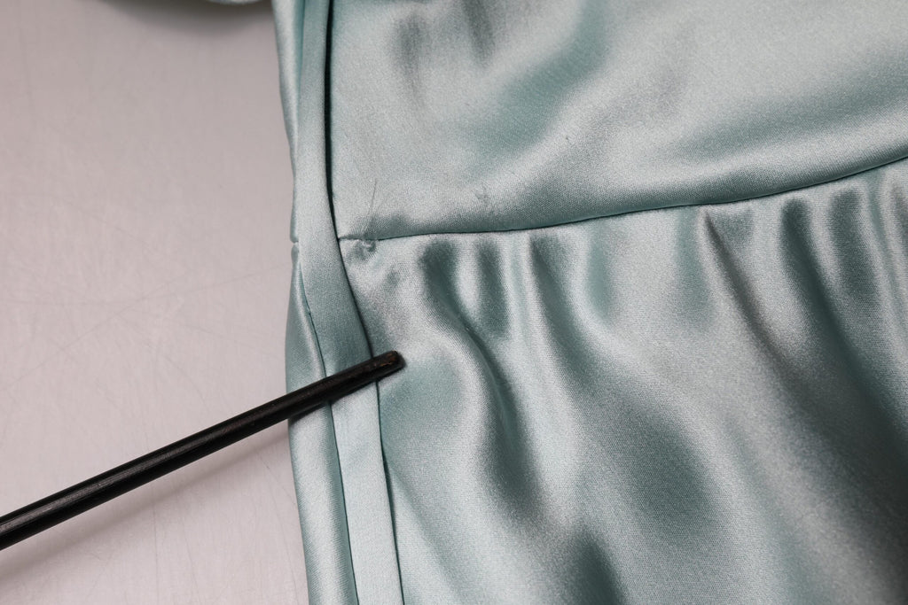 Robe en soie vert menthe Dolce & Gabbana, coupe ajustée et asymétrique, avec une épaule, visible sur l'image.