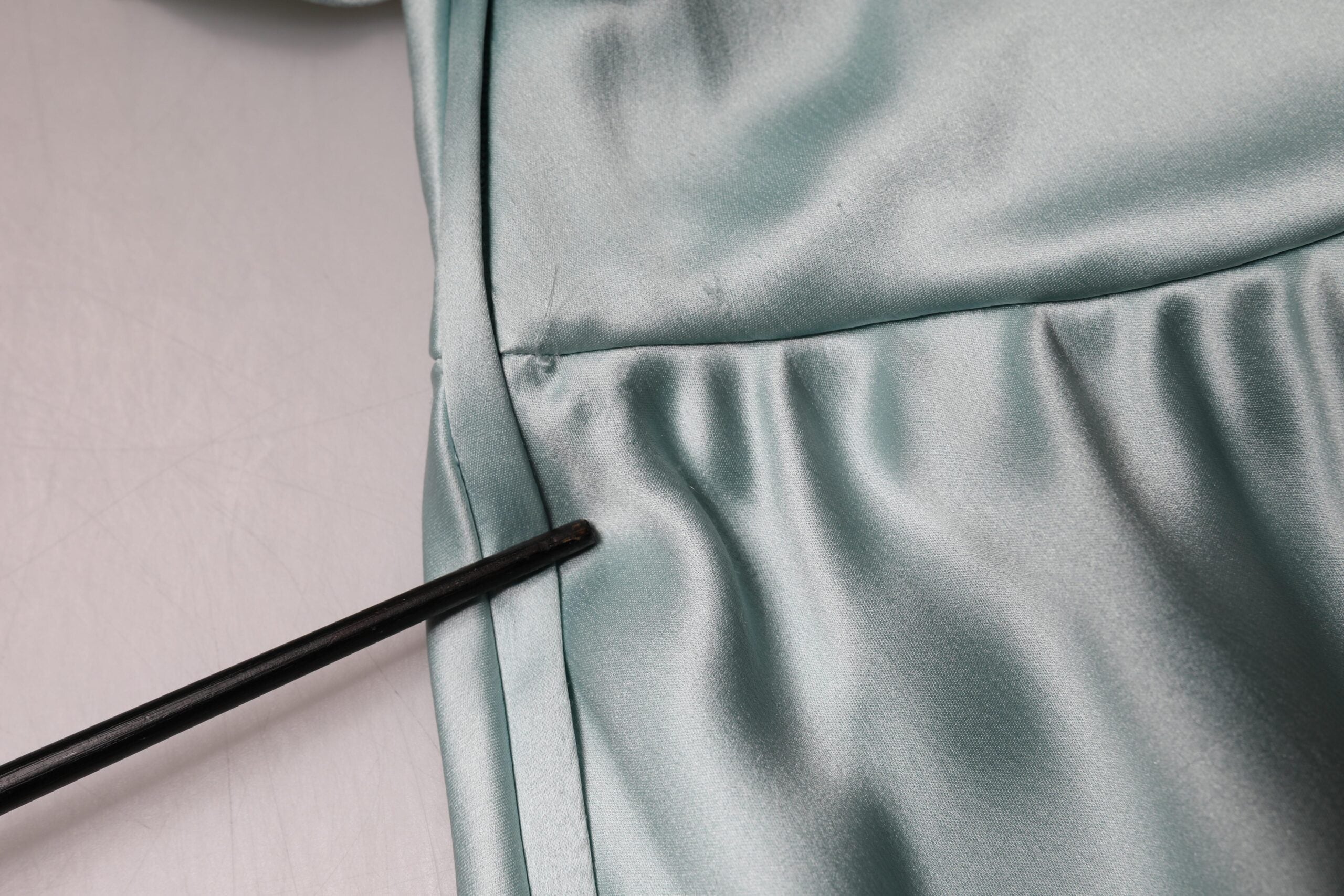 Robe en soie vert menthe Dolce & Gabbana, coupe ajustée et asymétrique, avec une épaule, visible sur l'image.