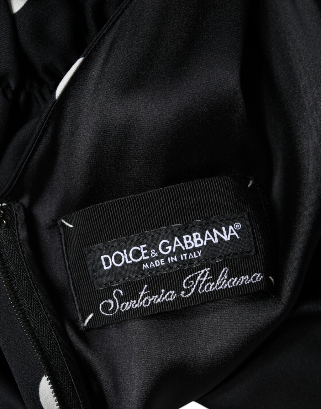 Robe midi en soie noire à pois Dolce & Gabbana avec col en V et franges, élégante et fluide, portée dans une vue en gros plan