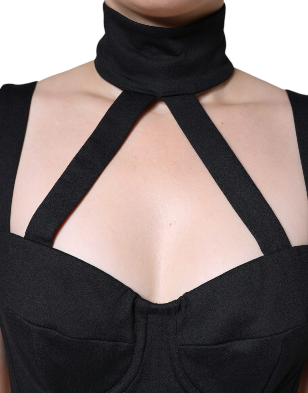 Robe courte sans manches Dolce & Gabbana noire, coupe moulante et découpes élégantes, portée sur mannequin.