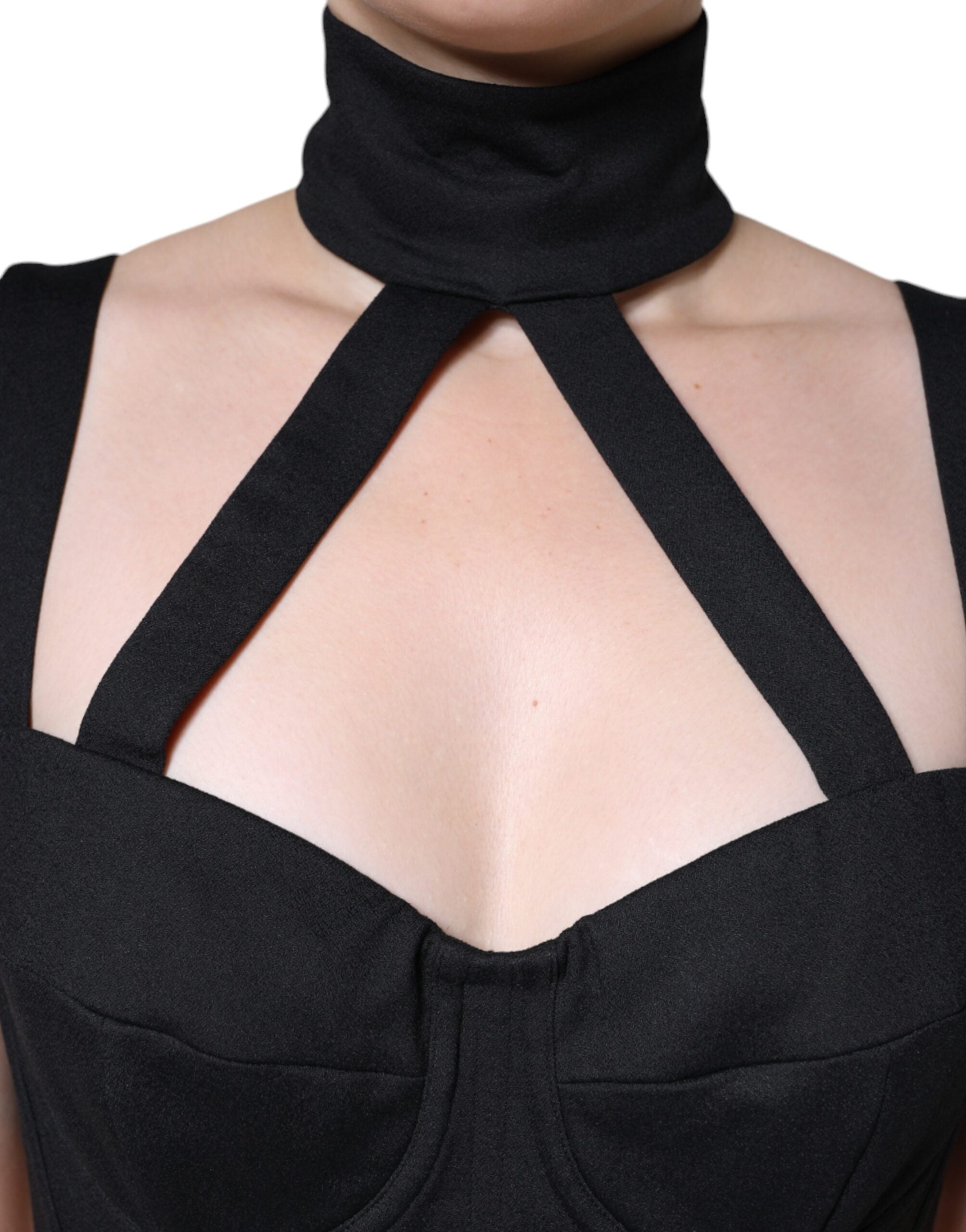 Robe courte sans manches Dolce & Gabbana noire, coupe moulante et découpes élégantes, portée sur mannequin.