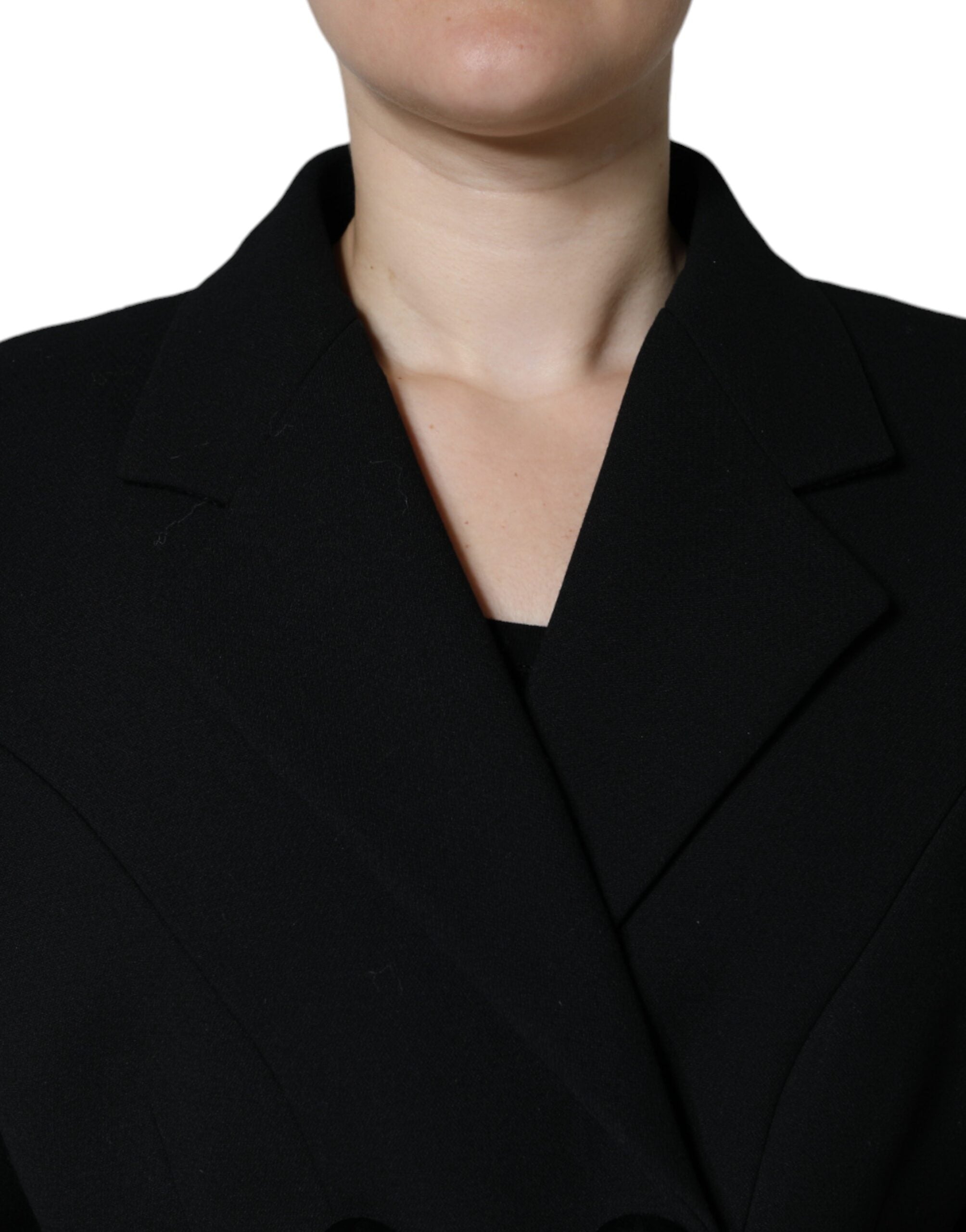 Manteau trench noir double boutonnage Dolce & Gabbana en tissu élégant, porté avec col et manches longues.