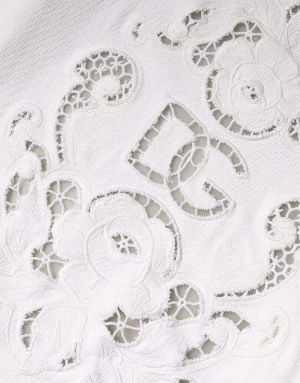 Cardigan Dolce & Gabbana en viscose blanche avec motifs floraux et découpes élégantes, porté sur un mannequin.