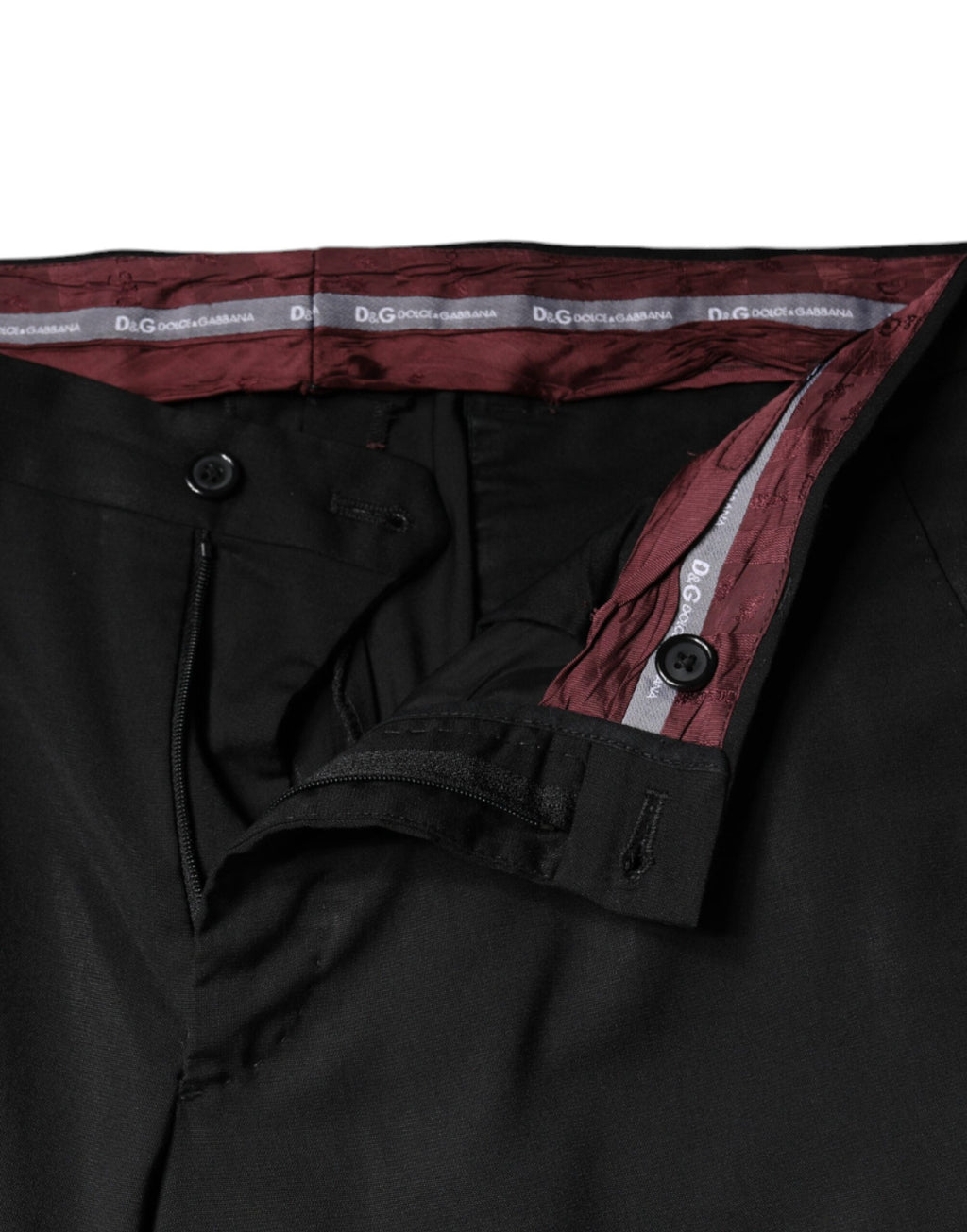 Pantalon noir en polyester à taille haute et coupe tapered par Dolce & Gabbana, vue en gros plan sur le tissu et la silhouette.