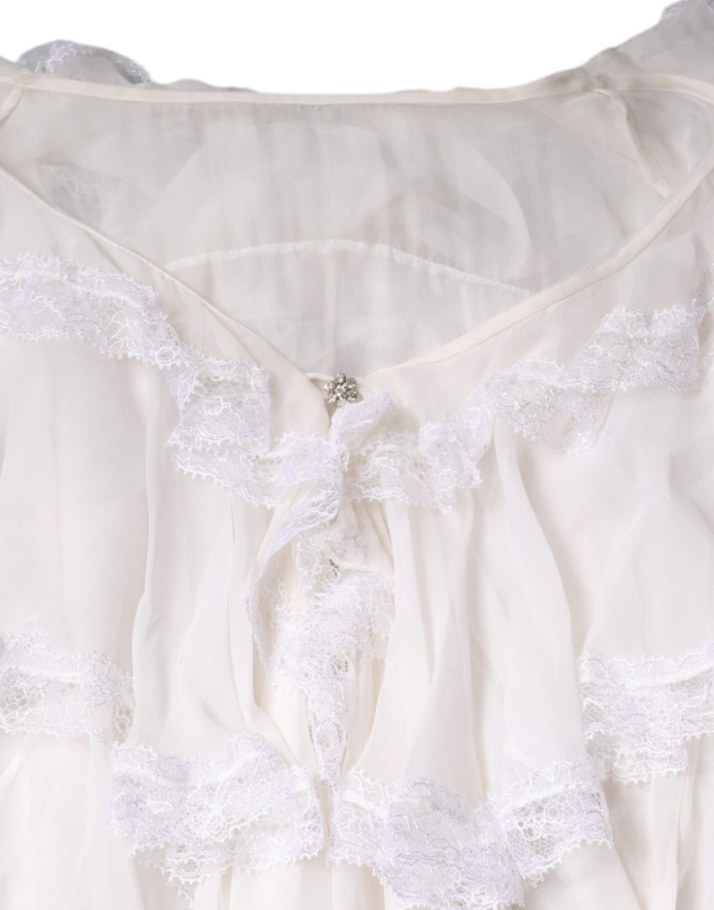 Chemisier blanc à manches longues Dolce & Gabbana avec volants en dentelle, élégant et féminin.