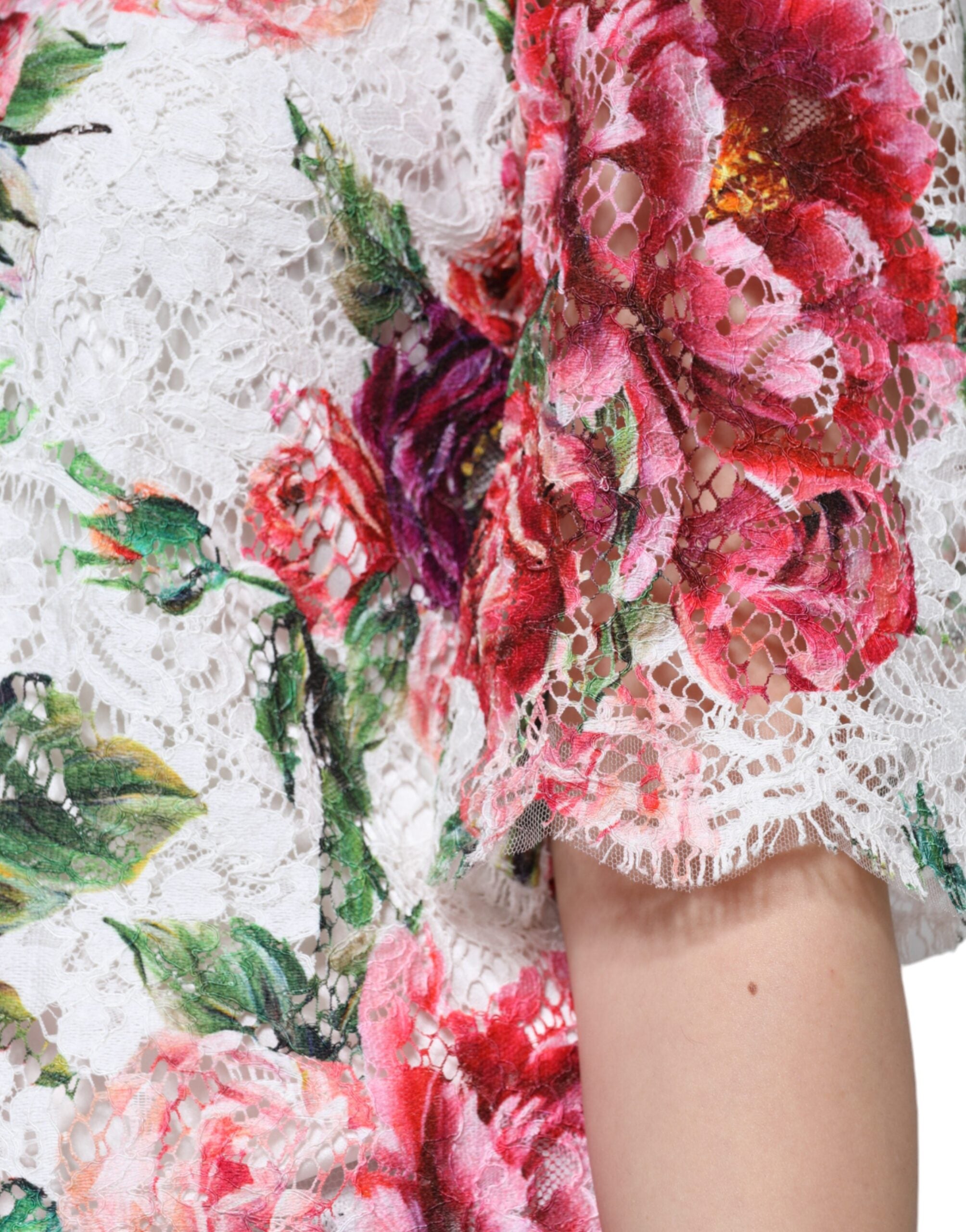 Blouse blanche Dolce & Gabbana en dentelle de pivoine avec manches courtes, élégante et raffinée, portée sur un mannequin.
