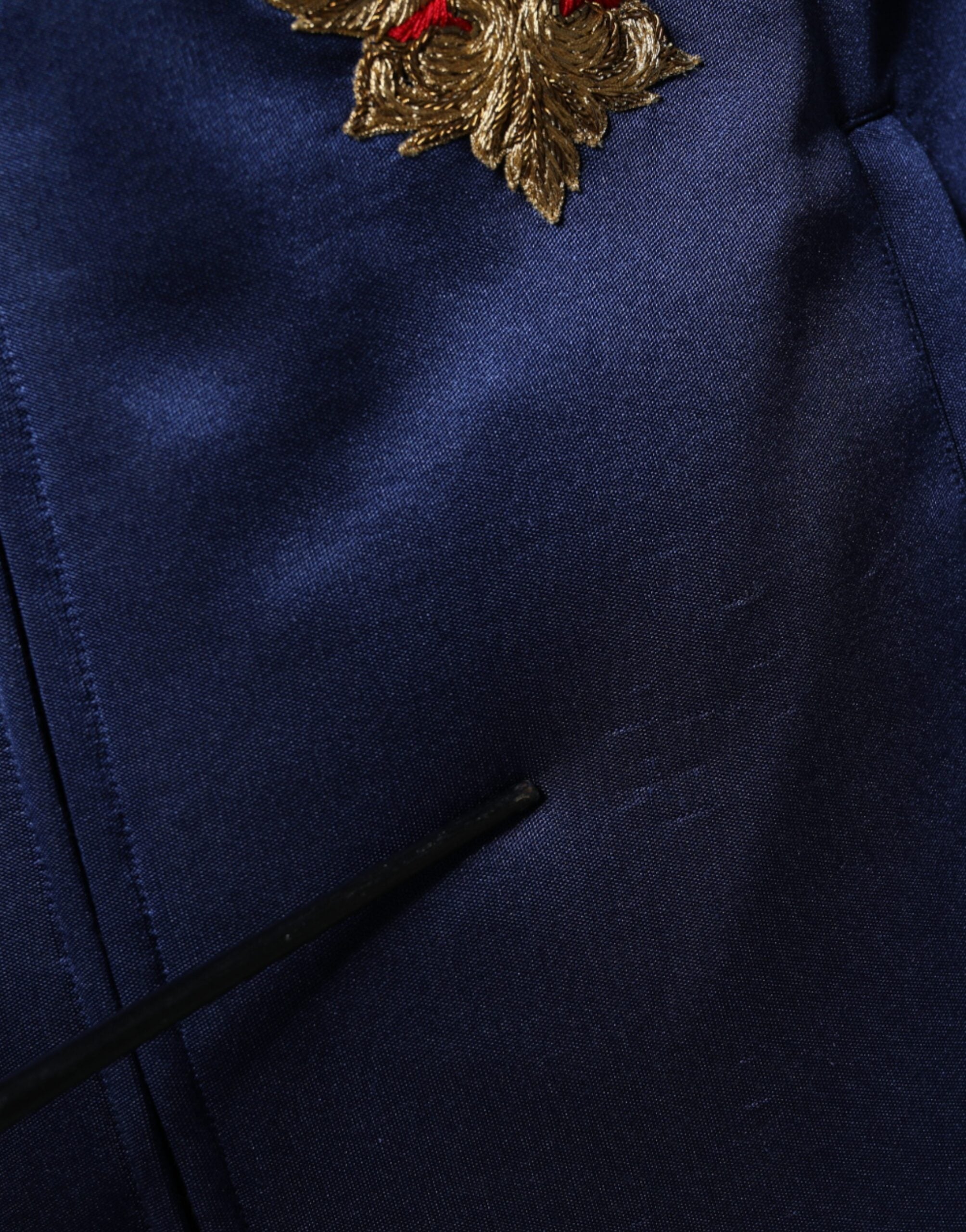 Pull Dolce & Gabbana bleu avec patch héraldique, rayures et motif abeille royale visible sur ce pull sophistiqué.
