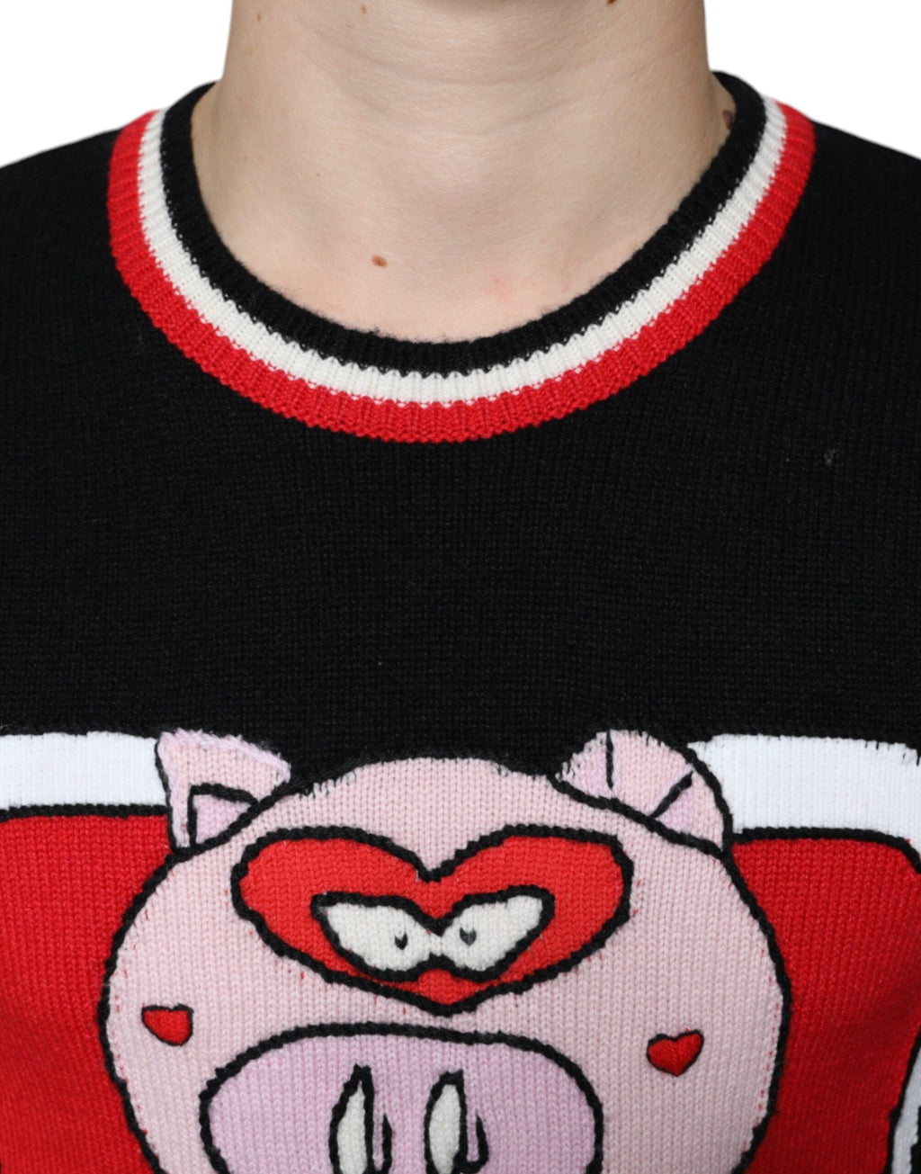 Pull Dolce & Gabbana en cachemire noir avec motif de cochon, douceur élégante et détails subtils visibles sur l'image.