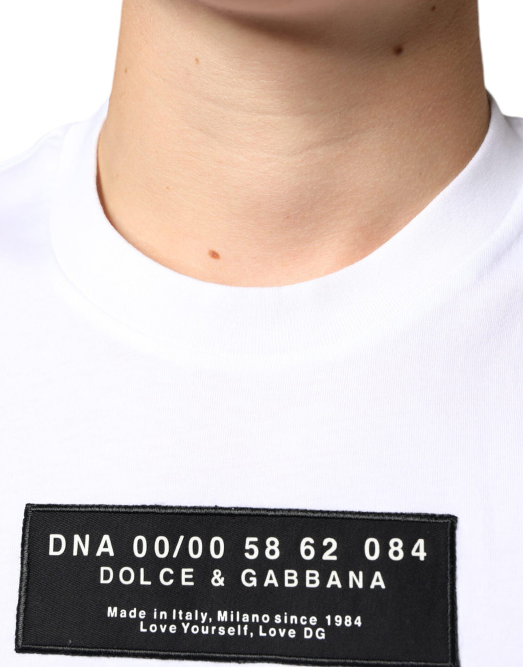 T-shirt blanc en coton Dolce & Gabbana avec appliqué DG, style décontracté et moderne visible sur l'image.