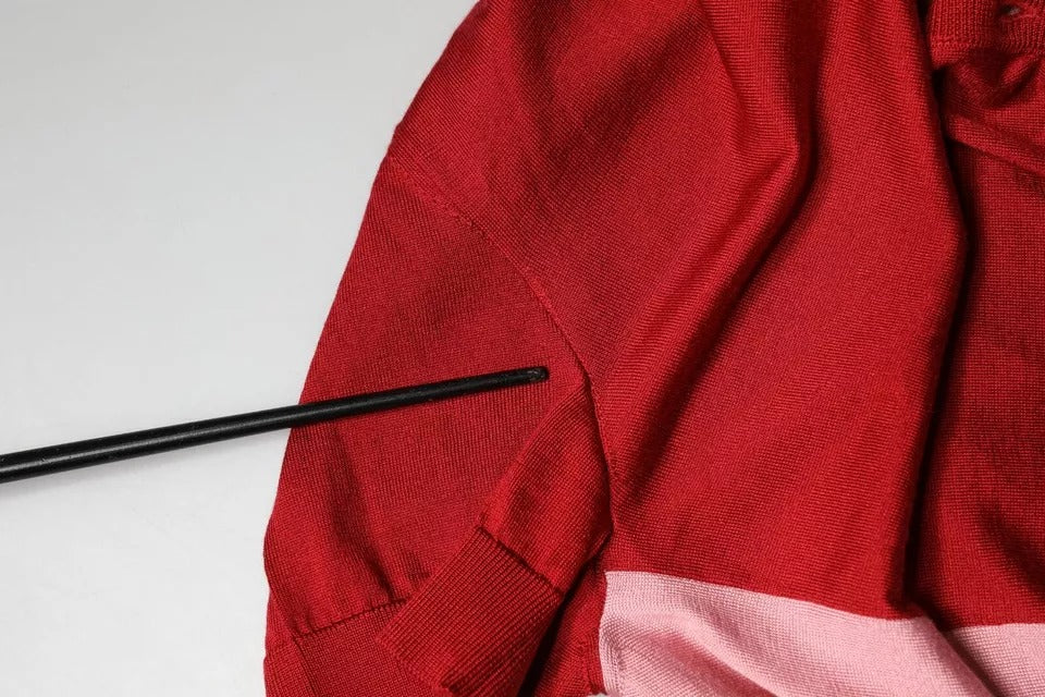 Pull à manches courtes rose Dolce & Gabbana avec col ascot, léger et élégant, visible en gros plan sur le haut du vêtement.