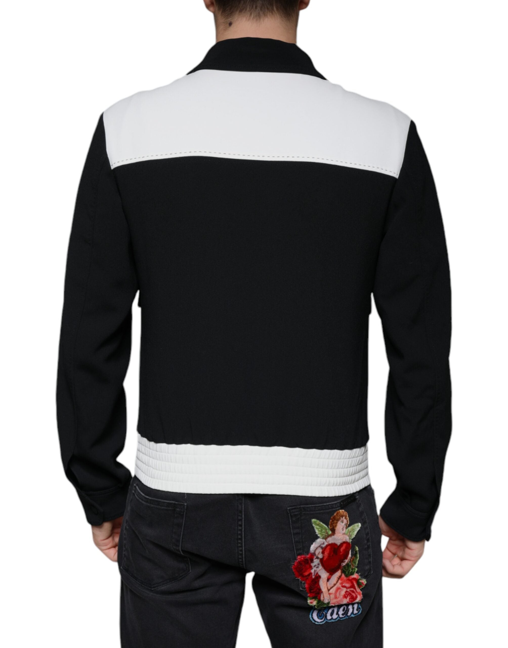 Veste blouson Dolce & Gabbana noire et blanche avec fermeture éclair et motif couronne DG, vue de face.