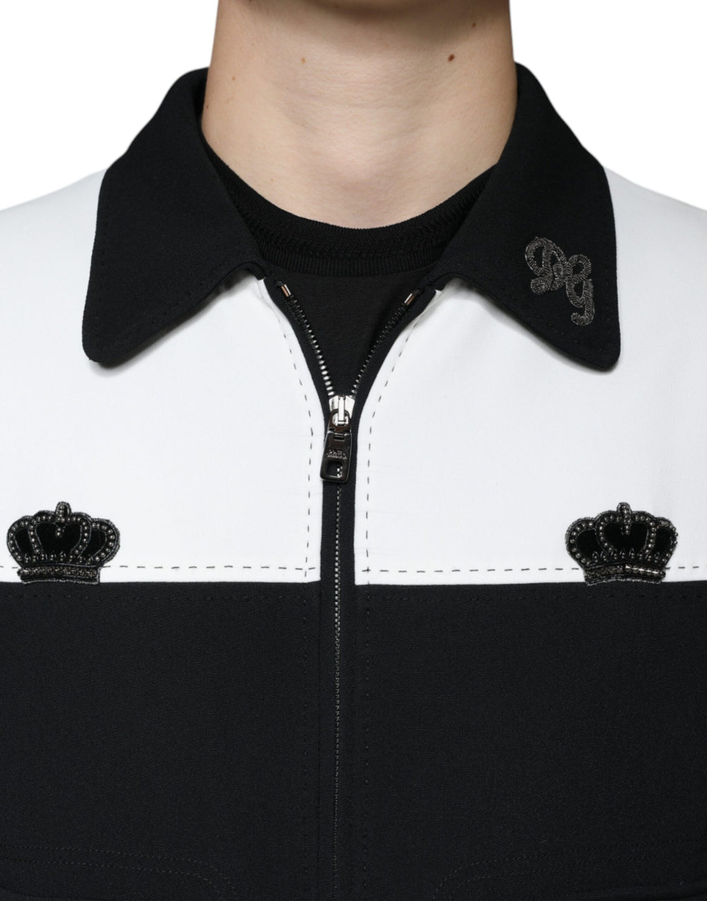 Veste blouson Dolce & Gabbana noire et blanche avec zip complet et motif couronne DG, porte-ouverte, vue de face.