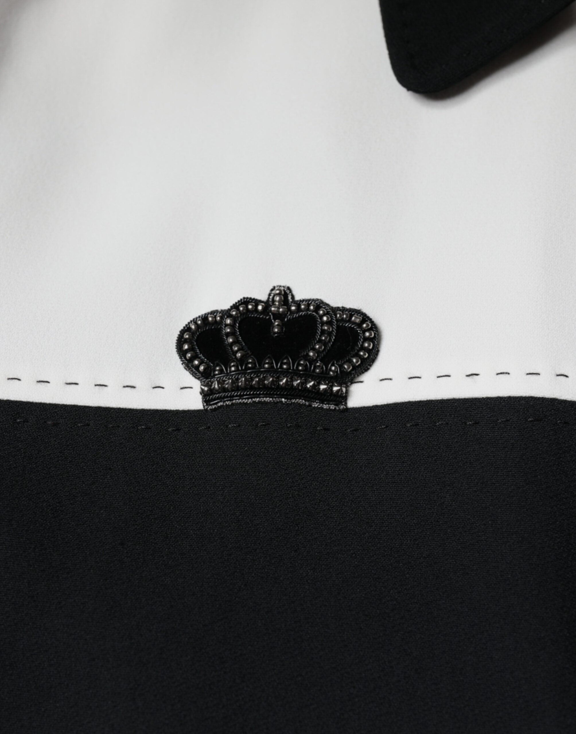 Veste blouson Dolce & Gabbana noire et blanche avec fermeture éclair complète et motif couronne DG visible sur l'image.